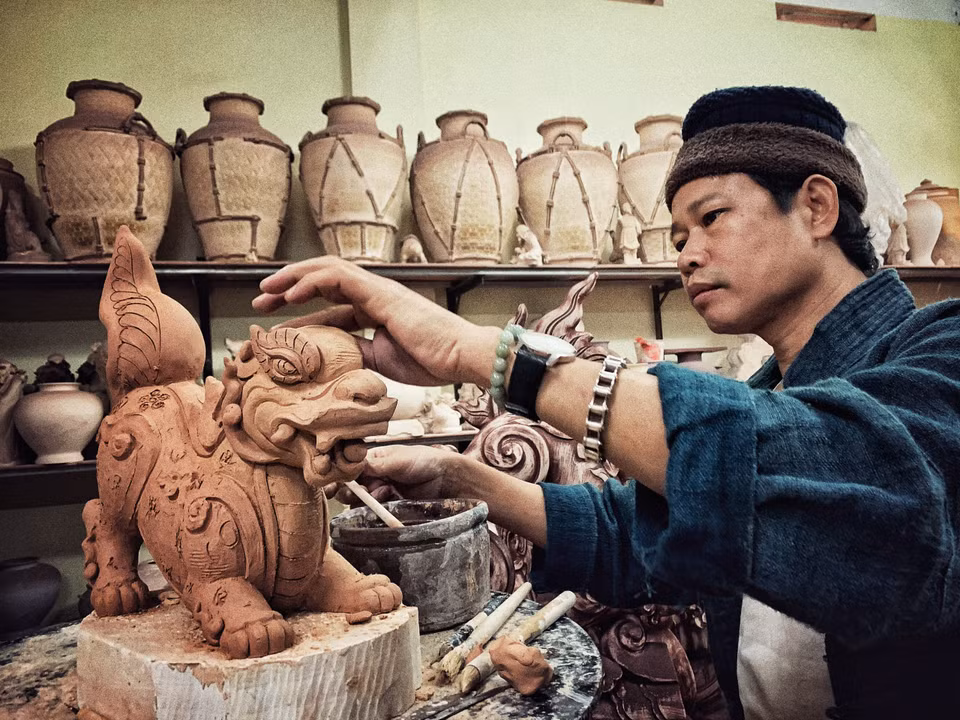 Anh đang hoàn thiện cặp Sấu thời Lý. (Ảnh: Xuân Mai/Vietnam+)