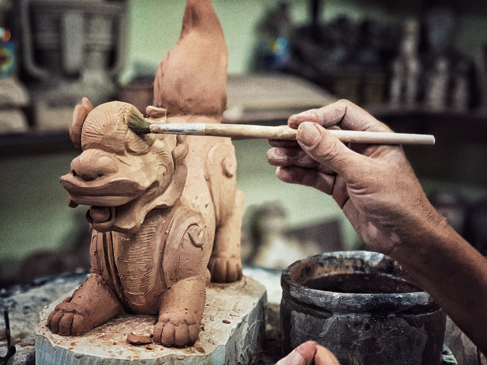 Để biến đất thành vàng, cùng một sản phẩm nhưng mỗi nghệ nhân có thể dùng các loại đất pha chế khác nhau, chất liệu màu khác nhau, thời gian nung qua lửa cũng như việc điều tiết nhiệt độ… khác nhau. (Ảnh: Xuân Mai/Vietnam+)