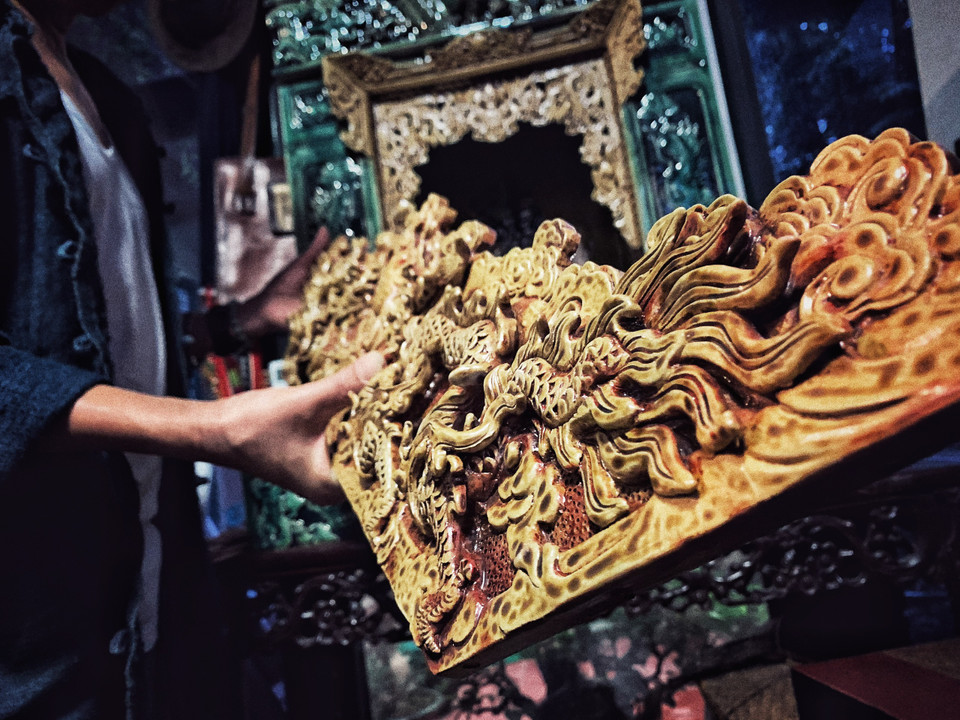 Khối gốm vuông làm thủ công mà chỉ dày 1cm là không dễ. Bởi người thợ phải tính toán cách phối trộn nguyên vật liệu và độ co rất kỹ để miếng gốm không bị xé khi nung qua nhiệt độ 1.200 độ C. (Ảnh: Xuân Mai/Vietnam+)