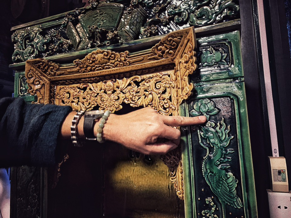 Với dòng men xanh ngọc được làm từ thủy tinh này, anh cũng phải tính toán kỹ để men chỉ chảy xuống tới chân khám thờ. Các họa tiết đều được đắp thủ công 'tay bo.' (Ảnh: Xuân Mai/Vietnam+)