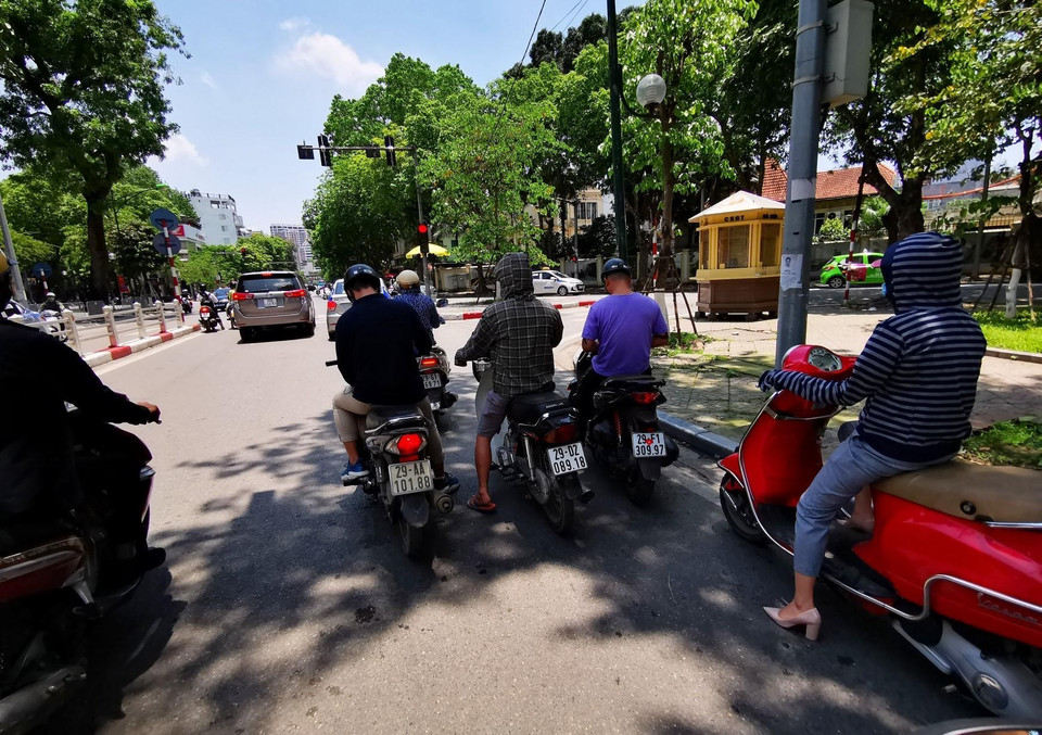 Bóng mát trên đường trở thành nơi tránh nắng lý tưởng của người dân. (Ảnh: Thành Đạt/TTXVN)