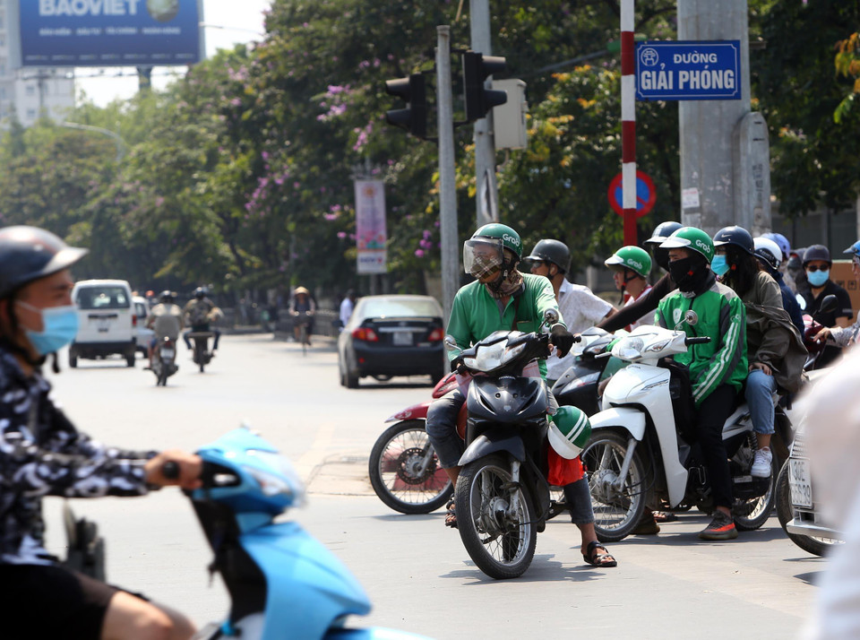 Các lái xe Grab hoạt động phục vụ khách trong cái nóng gần 40 độ C. (Ảnh: Danh Lam/TTXVN)