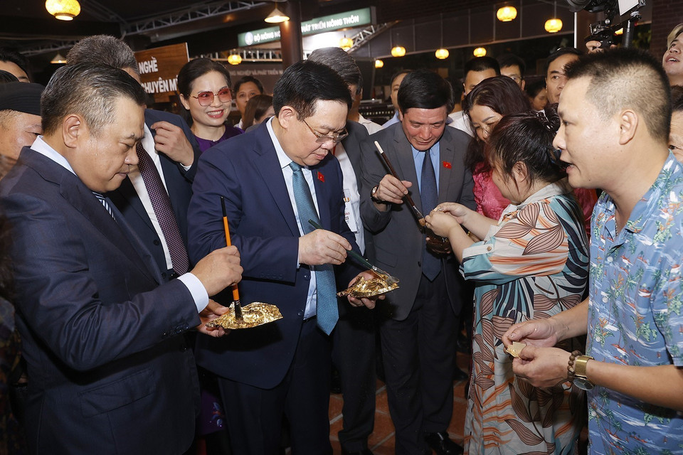 Chủ tịch Quốc hội Vương Đình Huệ tham gia dát vàng cùng nghệ nhân tại Khu trưng bày sản phẩm tham gia Hội thi Sản phẩm Thủ công Mỹ nghệ năm 2023. (Ảnh: Doãn Tấn/TTXVN)