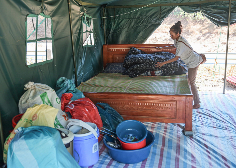 Người dân xóm Thượng dọn dẹp, sắp xếp đồ đạc tại nơi ở mới. (Ảnh: Hoàng Hiếu/TTXVN)