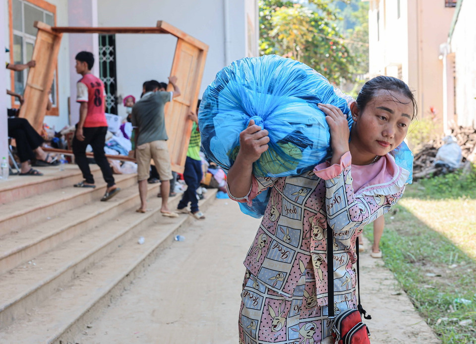 Người dân xóm Thượng chuyển lương thực, đồ đạc về nơi ở mới. (Ảnh: Hoàng Hiếu/TTXVN)