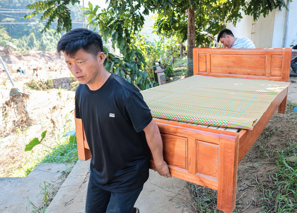 Người dân xóm Thượng chuyển đồ đạc về nơi ở mới. (Ảnh: Hoàng Hiếu/TTXVN)