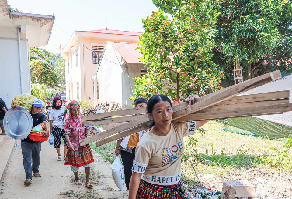 Người dân xóm Thượng chuyển đồ đạc về nơi ở mới. (Ảnh: Hoàng Hiếu/TTXVN)