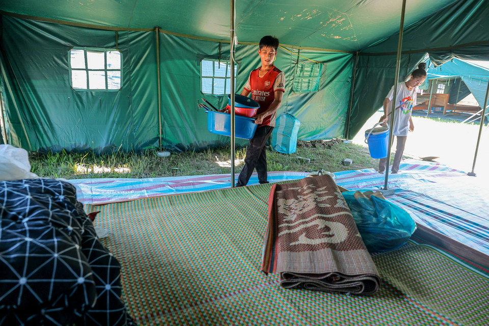 Gia đình anh Ma Sẹo Thái đang dọn dẹp đồ đạc tại nơi ở mới. (Ảnh: Hoàng Hiếu/TTXVN)