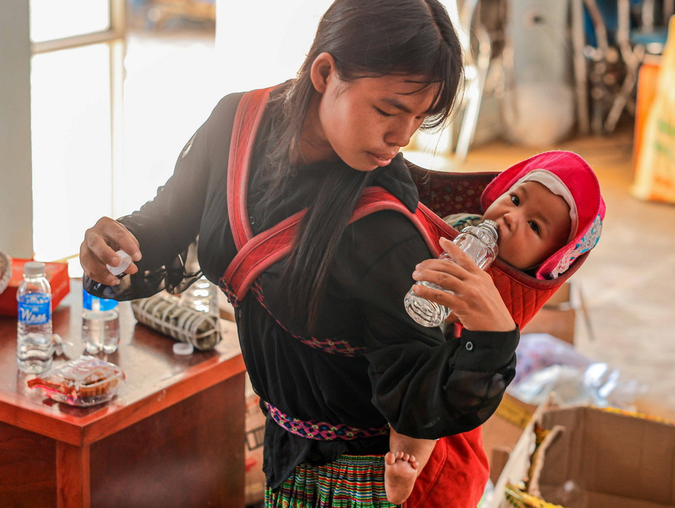 Trẻ em theo mẹ về nơi ở mới. (Ảnh: Hoàng Hiếu/TTXVN)