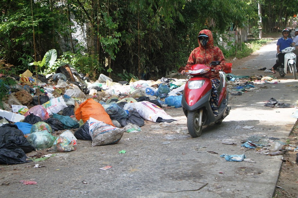 Người tham gia giao thông trên tuyến đường Huy Cận phải trùm kín mít vì mùi hôi thối. (Ảnh: Phan Quân/TTXVN)