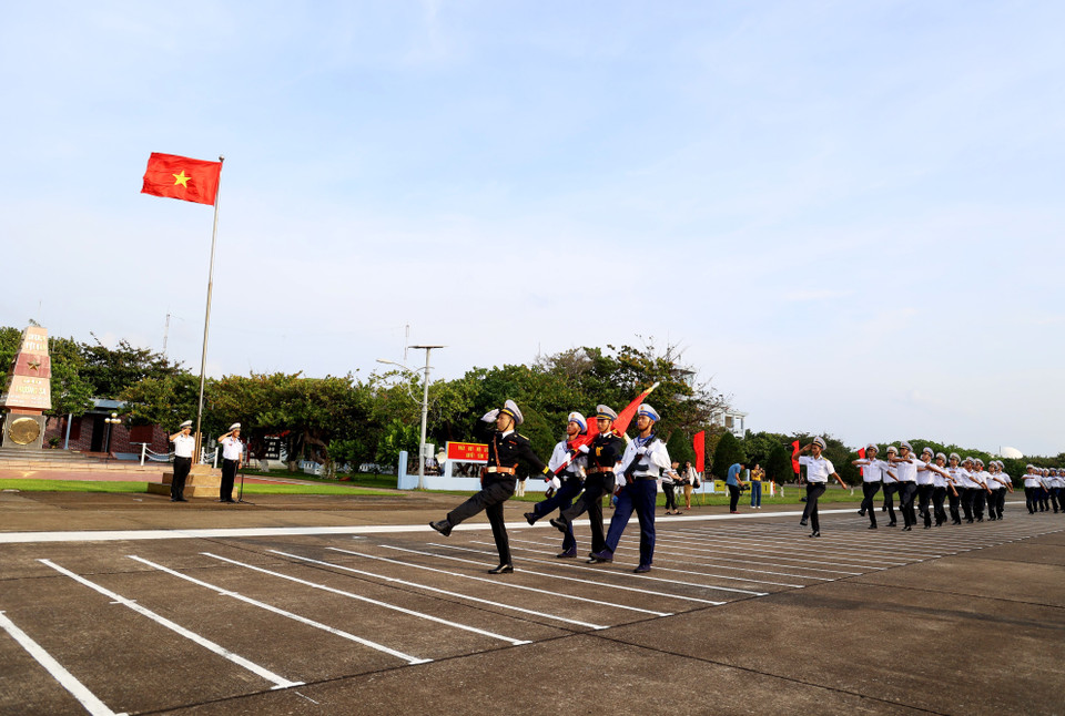 Đội danh dự với Quân kỳ Quyết thắng duyệt binh đi qua lễ đài trước cờ Tổ quốc và cột mốc chủ quyền đảo Trường Sa. (Ảnh: Hồng Đạt/TTXVN)