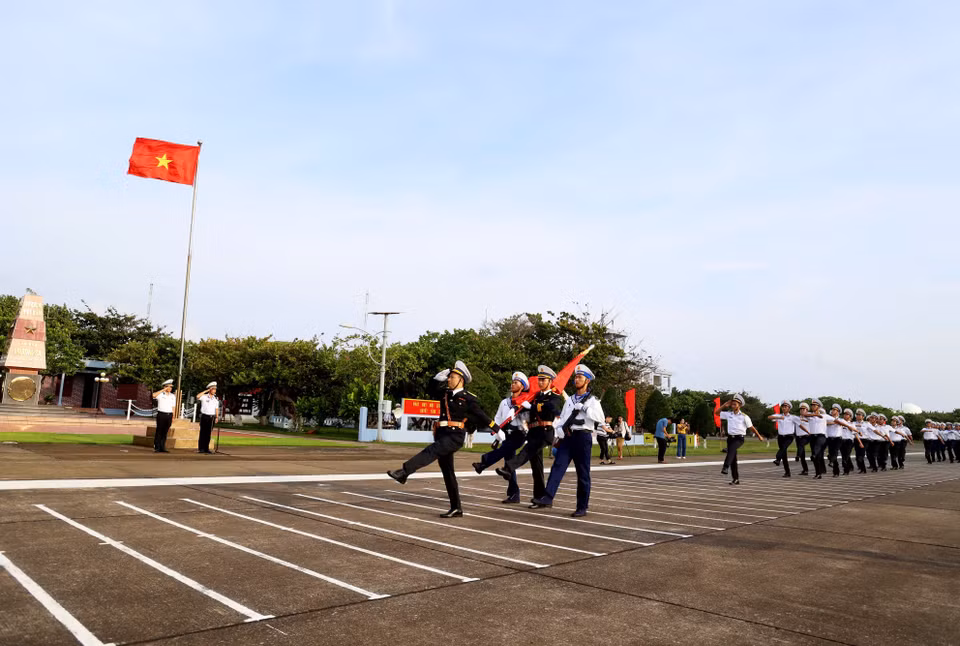 Đội danh dự với Quân kỳ Quyết thắng duyệt binh đi qua lễ đài trước cờ Tổ quốc và cột mốc chủ quyền đảo Trường Sa. (Ảnh: Hồng Đạt/TTXVN)