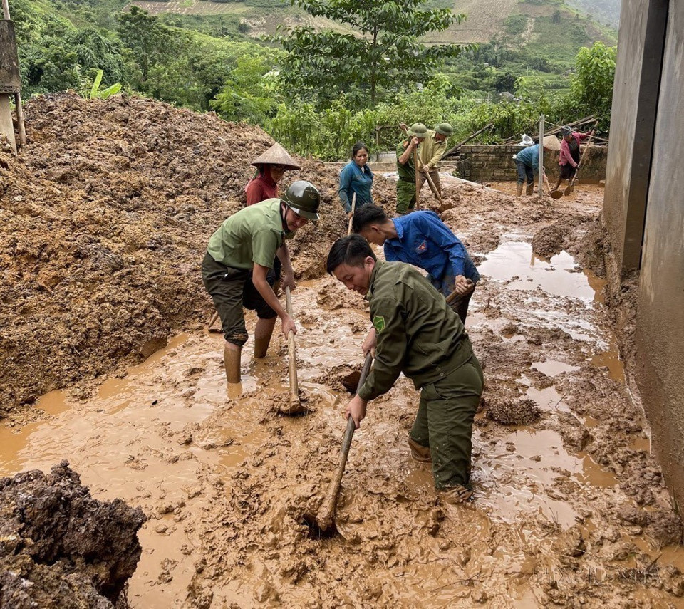 Công an tỉnh Lai Châu hỗ trợ người dân dọn bùn đất tràn vào nhà sau mưa lũ (2023). (Ảnh: TTXVN phát)