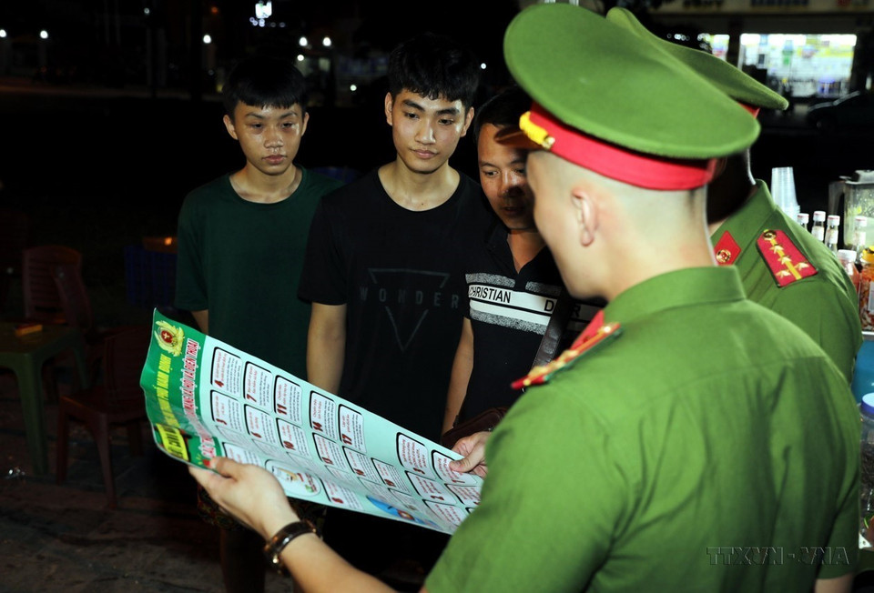 Công an thành phố Nam Định trực tiếp tuyên truyền tới người dân về việc phòng, chống lừa đảo qua mạng tại những địa điểm vui chơi buổi tối. (Ảnh: Thái Thuần/TTXVN)