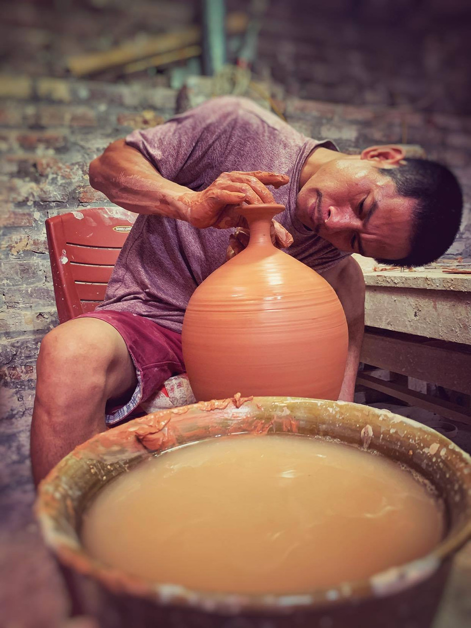 Một trận ốm từ năm đầu đời đã khiến Anh Đạo mất đi khả năng thính giác. Thế nhưng ngay từ nhỏ, Anh Đạo đã bộc lộ niềm yêu thích với gốm trong những lần xem bố vuốt, nặn... (Ảnh: Xuân Mai/Vietnam+)