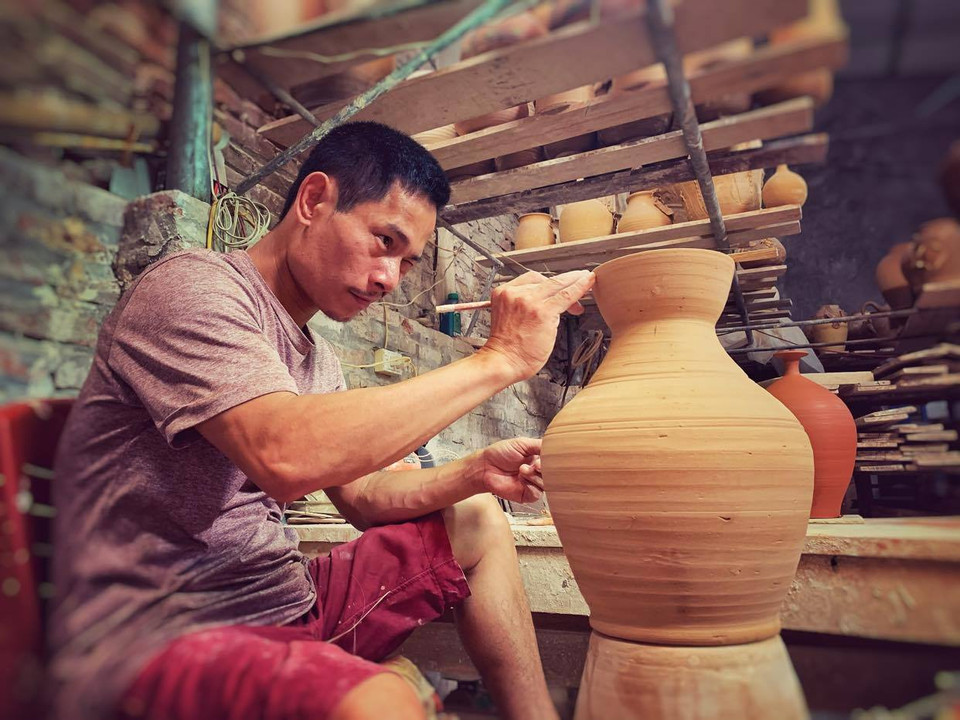 Mỗi sản phẩm sau khi nặn, vuốt, phơi sẽ được vẽ, nặn rồi vào men... (Ảnh: Xuân Mai/Vietnam+)