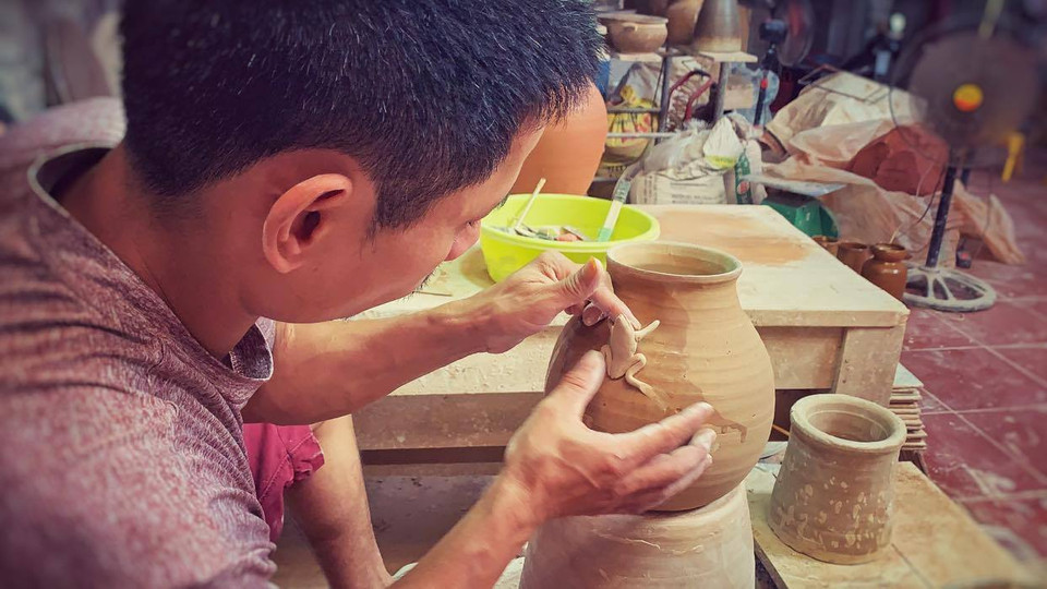 Trong khi các nghệ nhân khác sau một thời gian trụ vững ở Bát Tràng thường tìm cách mở rộng quy mô sản xuất thì Anh Đạo vẫn 'bảo thủ' với diện tích xưởng khiêm tốn của gia đình, và hàng ngày tỉ mẩn nặn, vuốt từng sản phẩm. (Ảnh: Xuân Mai/Vietnam+)