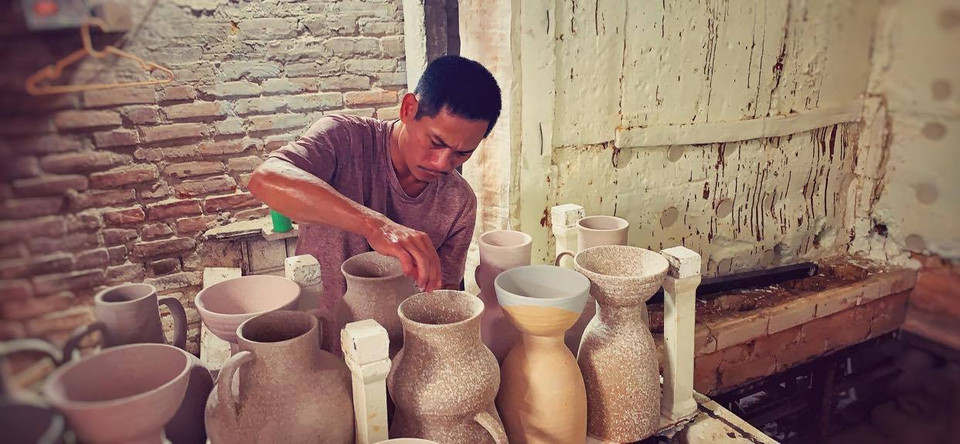 Công đoạn chồng lò. Cứ vài ngày Anh Đạo lại làm đủ để nung một mẻ gốm mới. (Ảnh: Xuân Mai/Vietnam+)