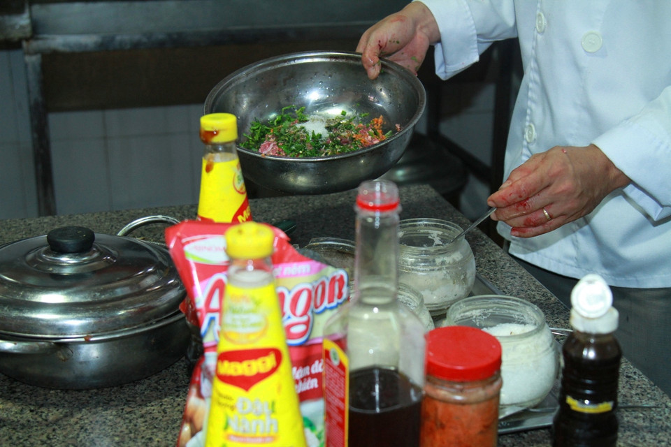 Trộn đều gia vị cho món ram đậm đà. (Ảnh: Xuân Mai/Vietnam+)