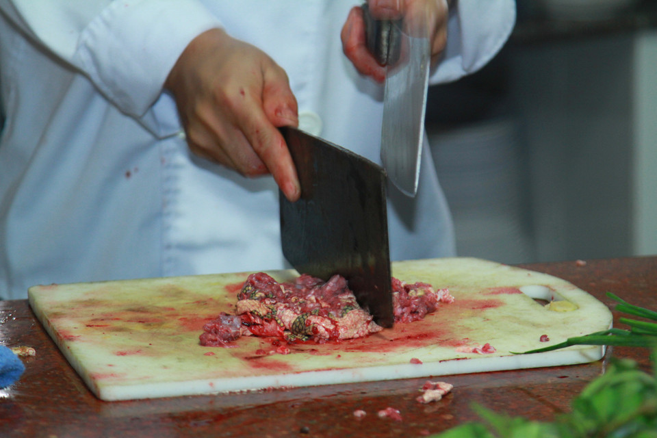 Xương đẻn cứng nên anh Hải phải băm rất kỹ mới có thể làm món ram. (Ảnh: Xuân Mai/Vietnam+)