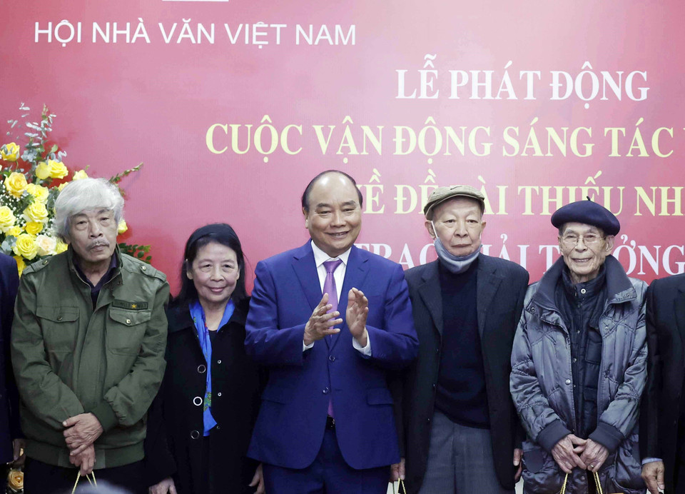 Chủ tịch nước Nguyễn Xuân Phúc tặng quà cho các nhà văn.(Ảnh: Thống Nhất/TTXVN)