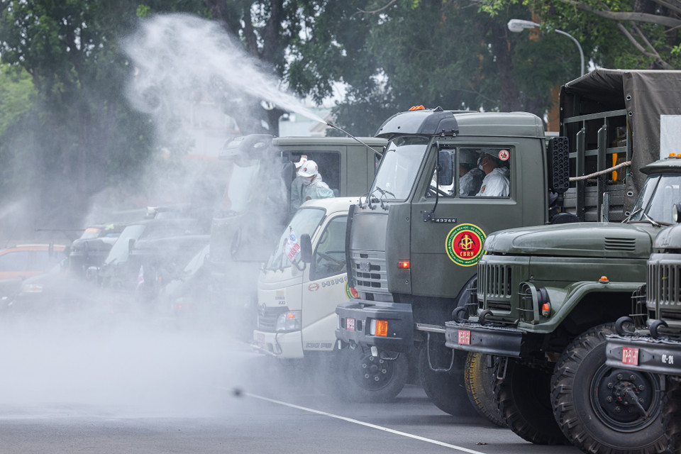 Xe chuyên dụng của lực lượng phòng hóa và Quân khu 7 tiến hành phun khử khuẩn trên các tuyến đường. (Nguồn: Vietnam+)