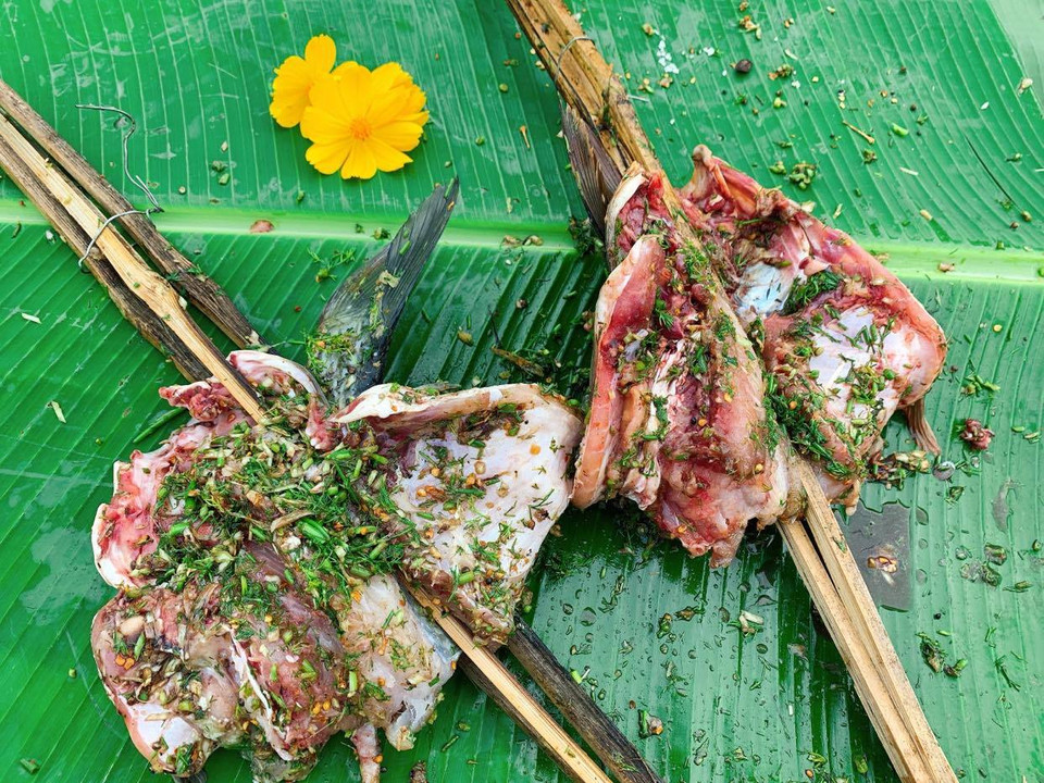 Món ăn được gọi 'cá gập nướng' vì dựa vào hình dáng của con cá khi đem nướng. Cá mổ sạch rồi tẩm ướp xong sẽ được gập đôi để nướng. (Ảnh: Xuân Mai/Vietnam+)