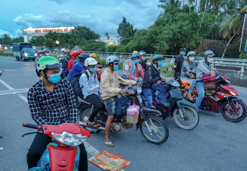 Người dân đi xe máy về quê ở Sóc Trăng, Bạc Liêu, Cà Mau bị kẹt lại giữa cầu số 10, giáp ranh giữa Cần Thơ và Hậu Giang, chiều 25/9. (Ảnh: Thanh Liêm/TTXVN)