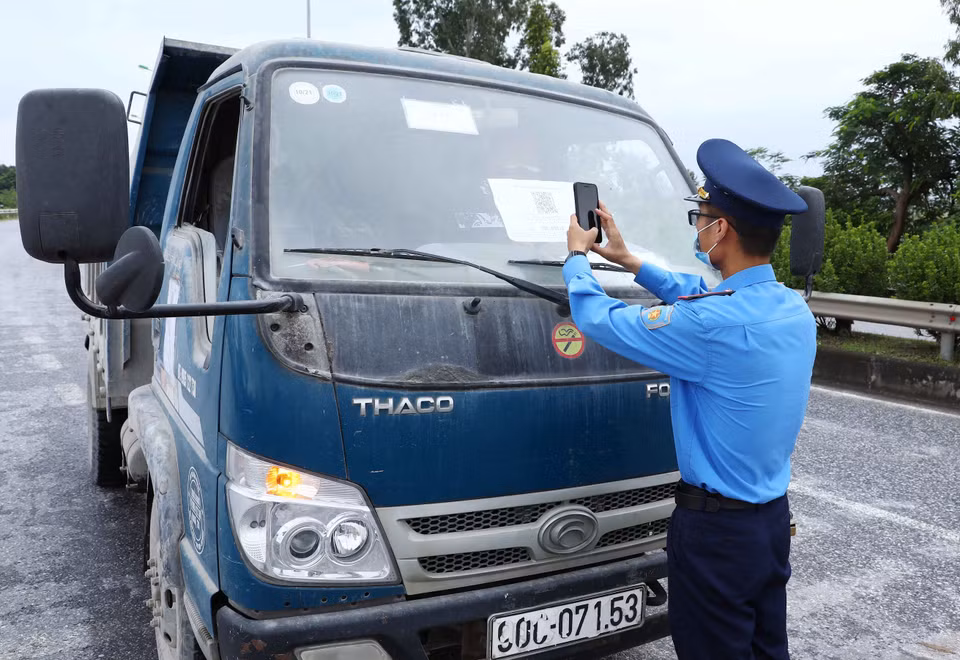 Lực lượng chức năng quét mã QR của phương tiện tham gia giao thông tại chốt kiểm soát dịch ngã 3 Cầu Giẽ, huyện Phú Xuyên hướng từ Hà Nam về Hà Nội trên tuyến Quốc lộ 1A. (Ảnh: Phạm Kiên/TTXVN)