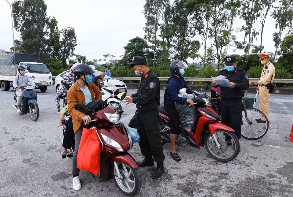 Lực lượng chức năng chốt kiểm soát dịch tại ngã 3 Cầu Giẽ, huyện Phú Xuyên hướng từ Hà Nam về Hà Nội trên tuyến Quốc lộ 1A yêu cầu người tham gia giao thông dừng phương tiện để kiểm tra giấy tờ và khai báo y tế. (Ảnh: Phạm Kiên/TTXVN)