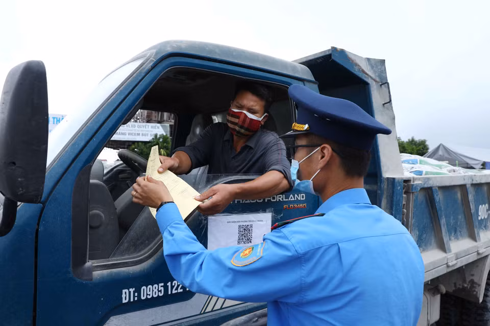 Lực lượng chức năng chốt kiểm soát dịch tại ngã 3 Cầu Giẽ, huyện Phú Xuyên hướng từ Hà Nam về Hà Nội trên tuyến Quốc lộ 1A yêu cầu người tham gia giao thông dừng phương tiện, kiểm tra giấy tờ và khai báo y tế. (Ảnh: Phạm Kiên/TTXVN)