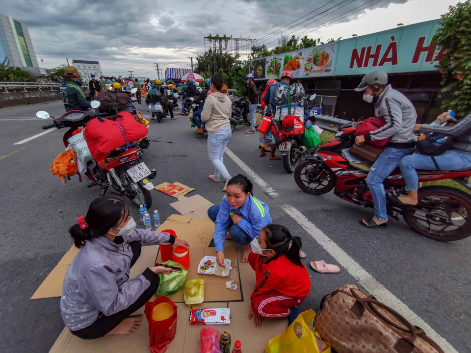 Người dân đi xe máy về quê bị kẹt giữa cầu số 10 giáp ranh giữa Cần Thơ và Hậu Giang, chiều 25/9. (Ảnh: Thanh Liêm/TTXVN)