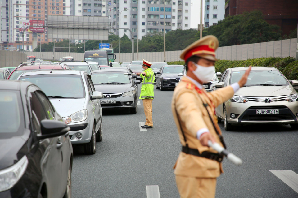 Lực lượng cảnh sát giao thông nhanh chóng có mặt phân luồng và hướng dẫn các phương tiện giao thông di chuyển để giảm ùn tắc. (Ảnh: Phạm Kiên/TTXVN)