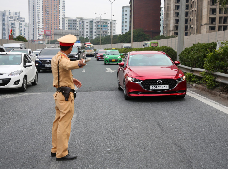 Lực lượng cảnh sát giao thông phân luồng và hướng dẫn các phương tiện giao thông di chuyển. (Ảnh: Phạm Kiên/TTXVN)