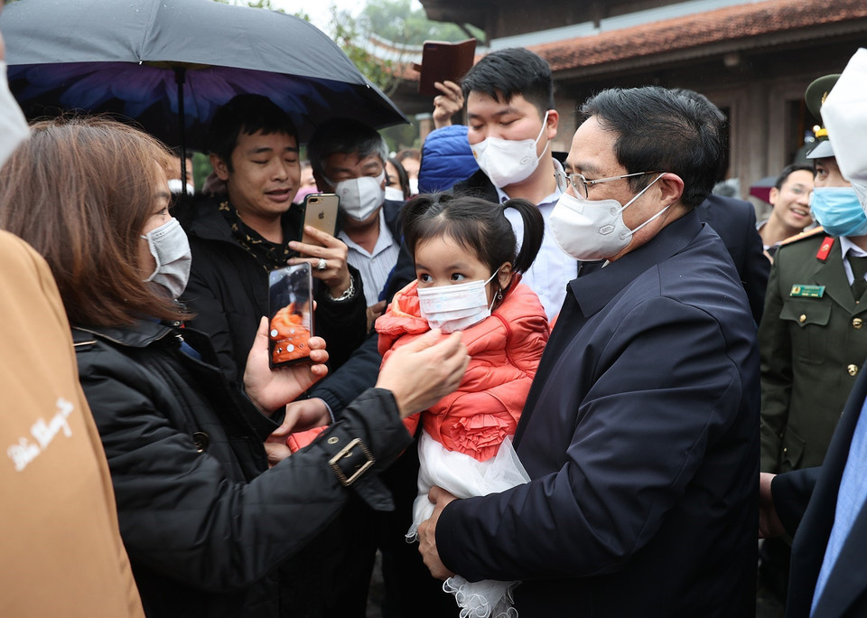 Thủ tướng Phạm Minh Chính trò chuyện với người dân đang du Xuân đón Tết tại Khu Di tích Kim Liên. (Ảnh: Dương Giang/TTXVN)