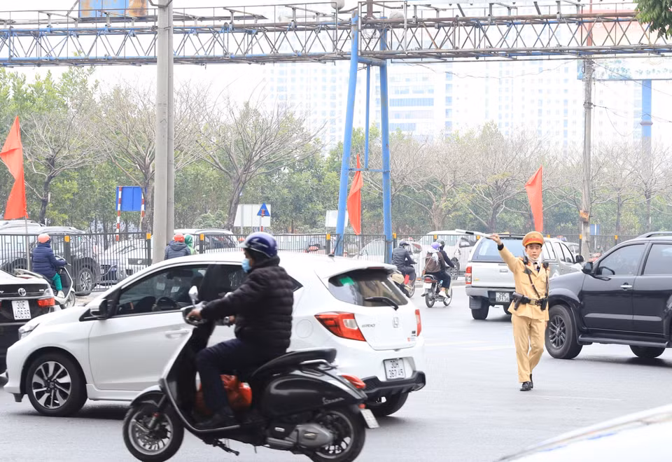 Lực lượng chức năng tiến hành phân luồng, điều tiết giao thông để bảo đảm an toàn cho người dân về quê đón Tết. (Ảnh: Hoài Nam/Vietnam+)