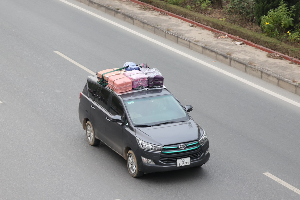 Một số người dân với lượng hành lý 'quá khổ' đã phải chia nhỏ để buộc cố định trên nóc xe ôtô. (Ảnh: Minh Sơn/Vietnam+)
