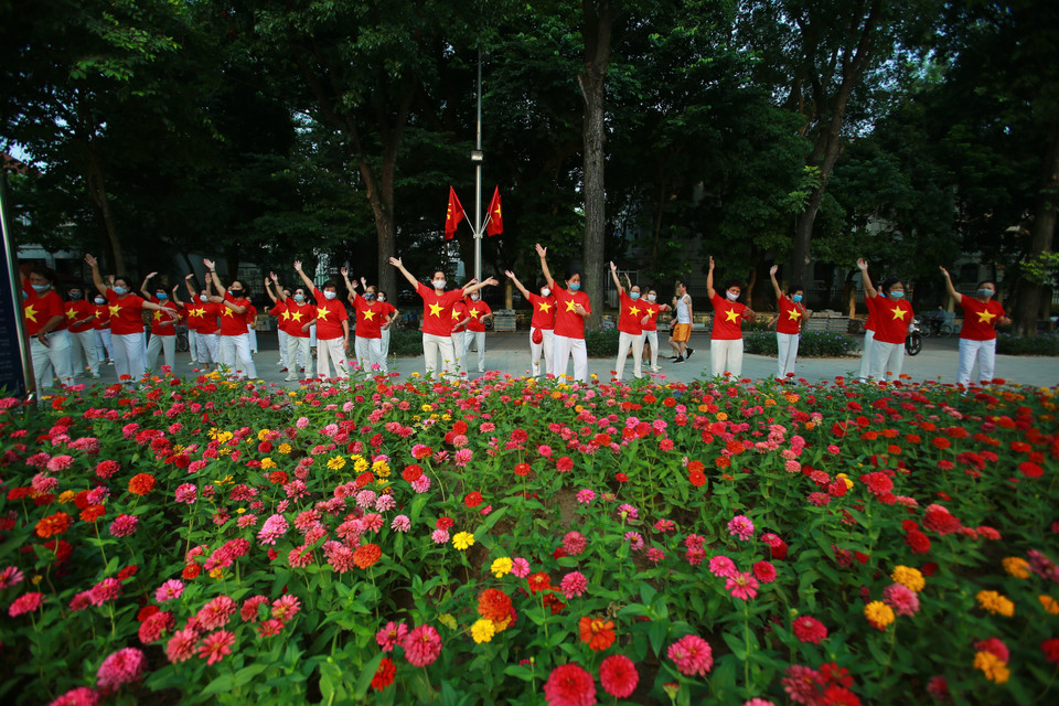 Người dân đồng diễn thể dục với áo mang hình Quốc kỳ trong ngày Quốc khánh 2/9. (Ảnh: TTXVN)