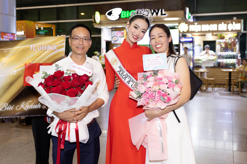 Bùi Khánh Linh trong vòng tay bố mẹ. (Ảnh: CTV/Vietnam+)