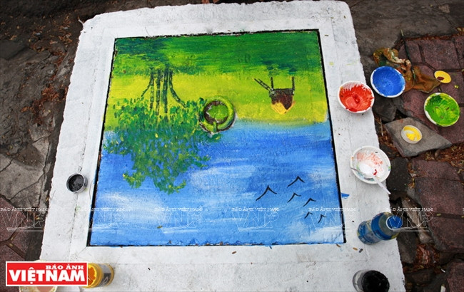 Những bức tranh phong cảnh được trang trí khá sinh động trên những chiếc nắp cống.