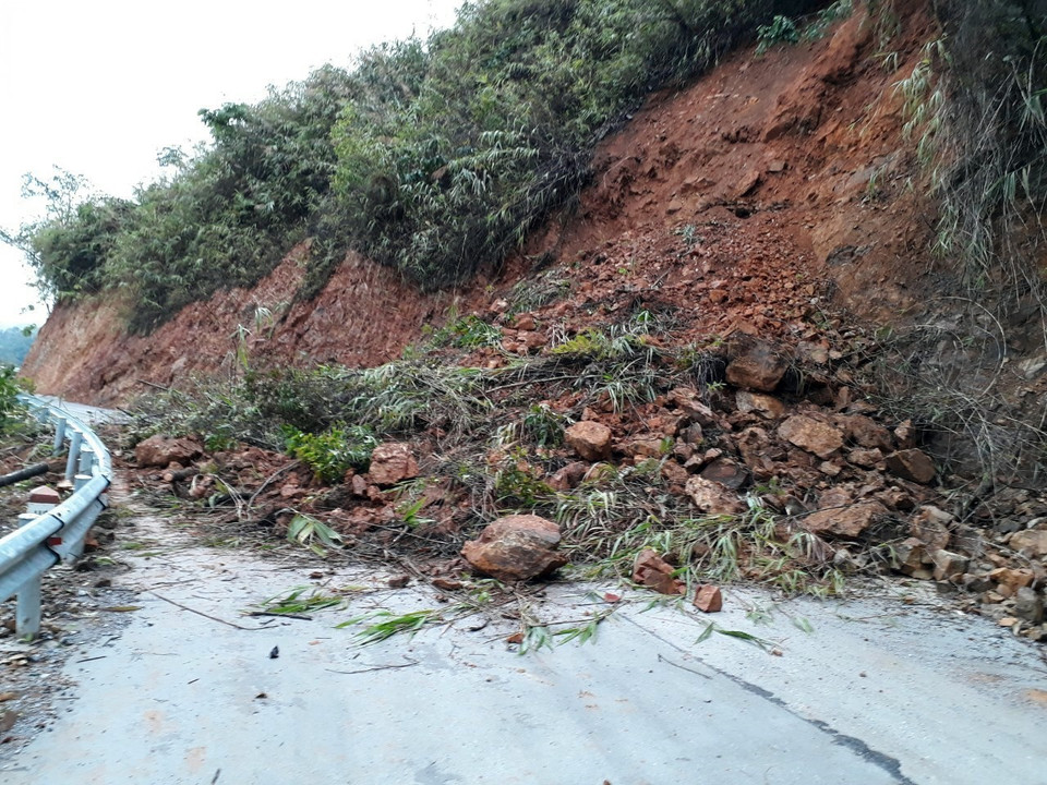 Đất đá bị cuốn trôi trên mặt đường gây khó khăn cho các phương tiện tham gia giao thông tại km 109 trên Quốc lộ 279. (Ảnh: Phan Tuấn Anh/TTXVN)