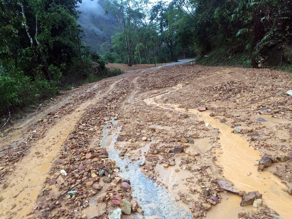 Đất đá bị cuốn trôi trên mặt đường gây khó khăn cho các phương tiện tham gia giao thông tại km 109 trên Quốc lộ 279. (Ảnh: Phan Tuấn Anh/TTXVN)