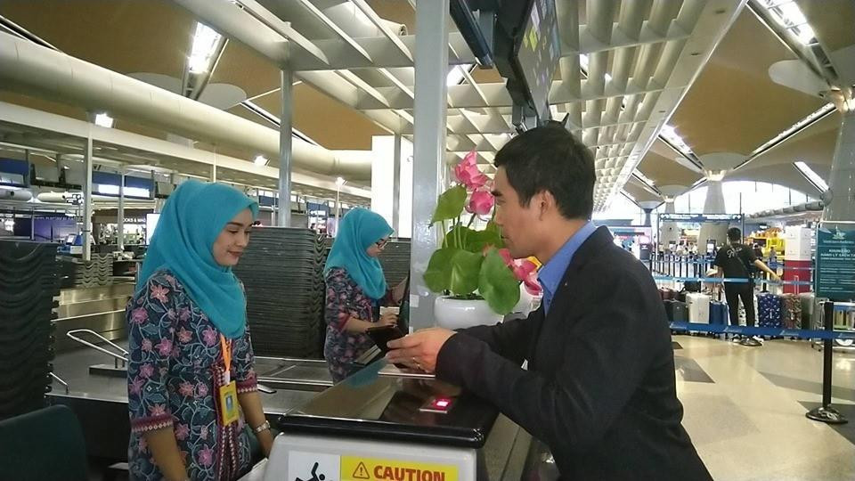 Trước đó, cán bộ Đại sứ quán Việt Nam hỗ trợ làm thủ tục check-in cho Đoàn Thị Hương lên máy bay từ Kuala Lumpur về Hà Nội. (Ảnh: Hà Ngọc/TTXVN)