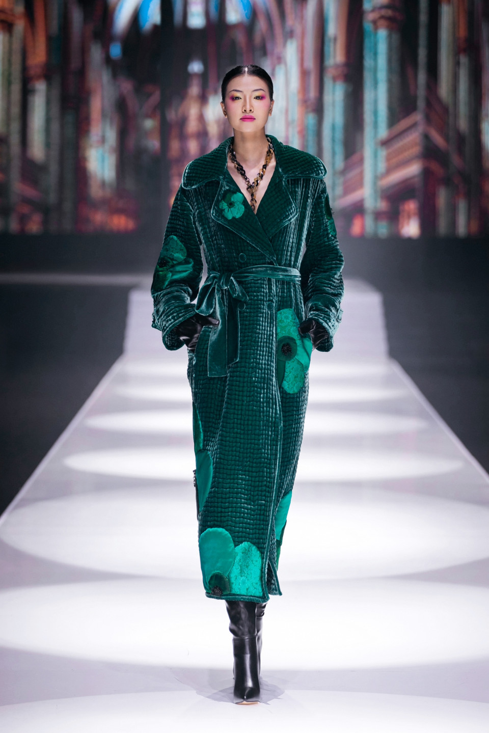 Các gam màu nóng như đỏ và nâu tượng trưng cho sự cuồng nhiệt và đam mê, trong khi sắc xanh ngọc lục bảo và xanh ngọc lam lại gợi lên cảm giác cô đơn, trống trải. Tất cả được thể hiện trên các chất liệu cao cấp như nhung và lụa, tạo nên chiều sâu cảm xúc trong từng thiết kế. (Ảnh: PV/Vietnam+)