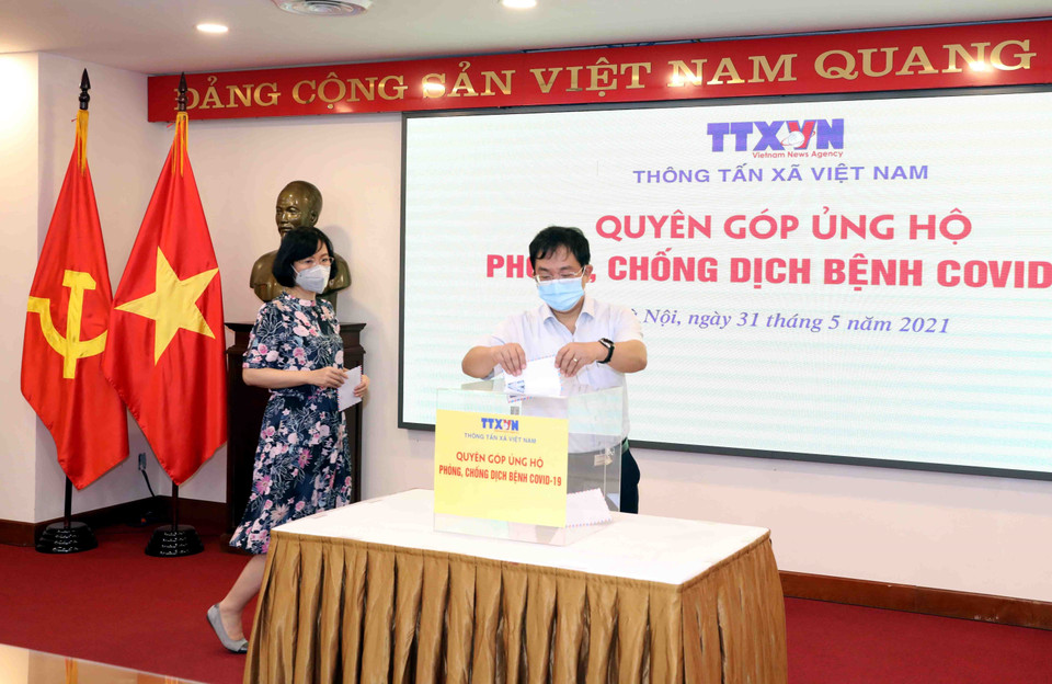Phó Tổng Giám đốc TTXVN Nguyễn Tuấn Hùng quyên góp, ủng hộ Quỹ phòng, chống dịch COVID-19. (Ảnh: Phạm Kiên/TTXVN)