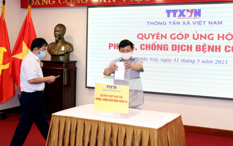 Phó Tổng Giám đốc, Chủ tịch Công đoàn TTXVN Đinh Đăng Quang quyên góp, ủng hộ Quỹ phòng, chống dịch COVID-19. (Ảnh: Phạm Kiên/TTXVN)