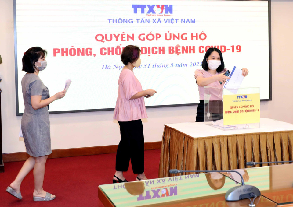 Lãnh đạo, cán bộ, phóng viên, biên tập viên và người lao động của Thông tấn xã Việt Nam tham gia quyên góp, ủng hộ Quỹ phòng, chống dịch COVID-19. (Ảnh: Phạm Kiên/TTXVN)