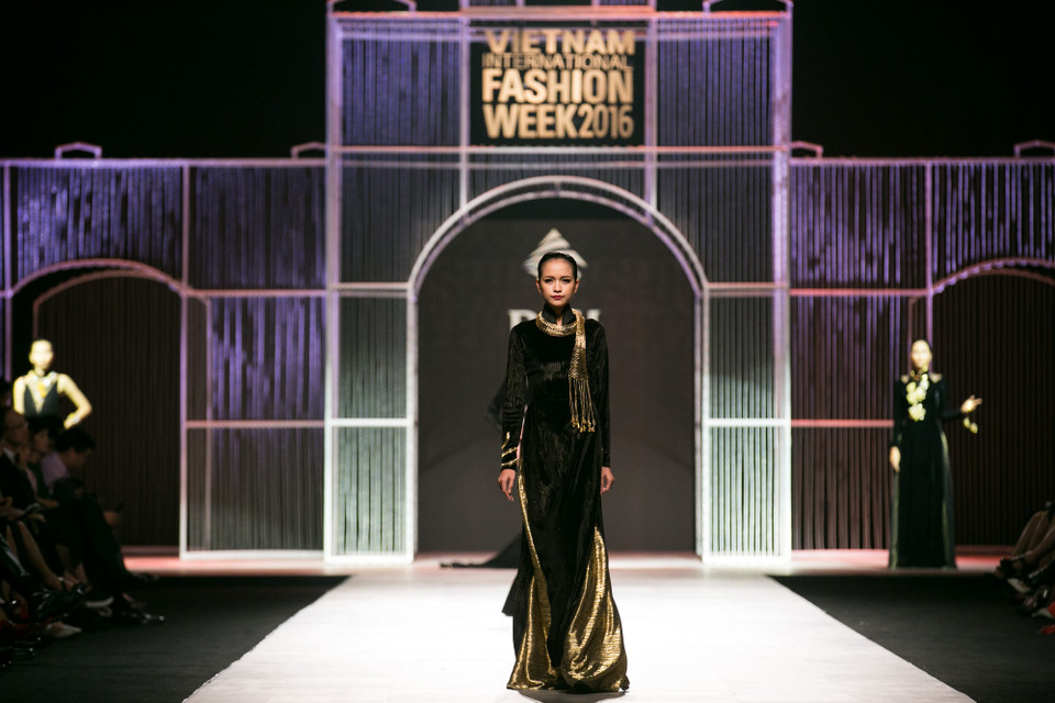 Trên nền nhạc “Hello Vietnam,” Quán quân Vietnam’s Next Top Model mùa thứ 7 Ngọc Châu mở màn show diễn với chiếc áo dài đen cách điệu bằng chất liệu nhung. (Ảnh: BTC)