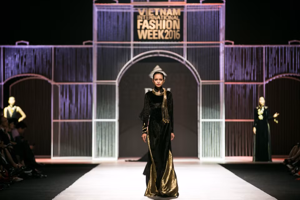Trên nền nhạc “Hello Vietnam,” Quán quân Vietnam’s Next Top Model mùa thứ 7 Ngọc Châu mở màn show diễn với chiếc áo dài đen cách điệu bằng chất liệu nhung. (Ảnh: BTC)