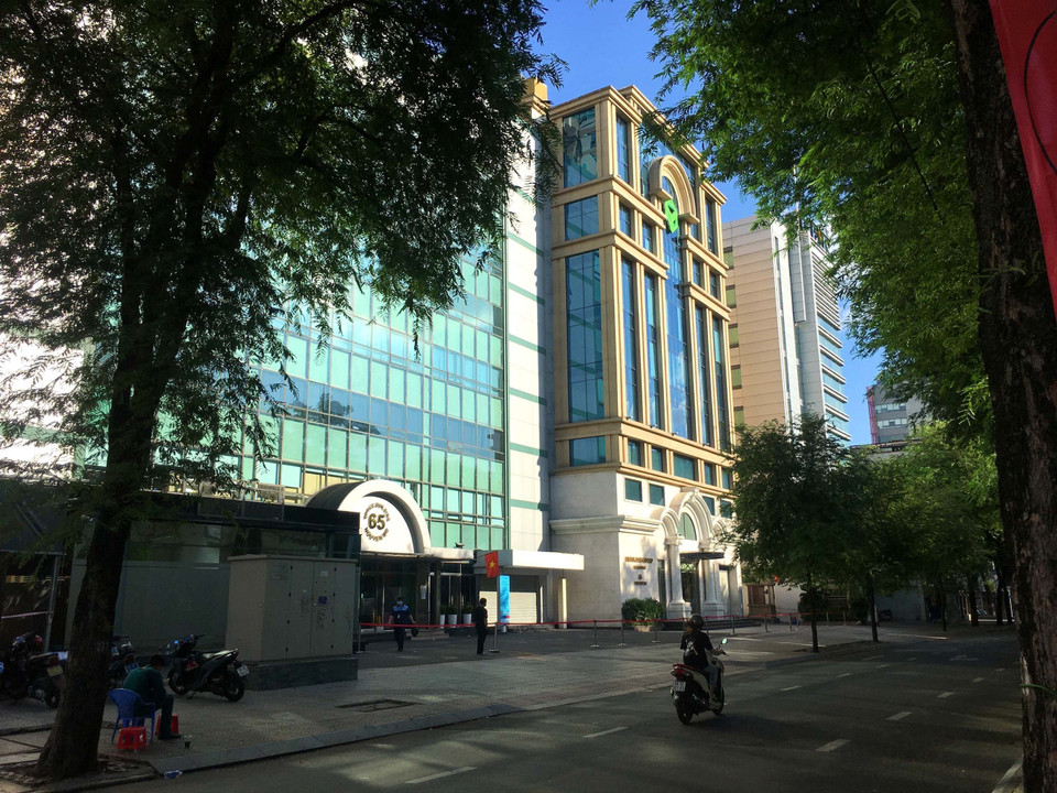 Các lực lượng chức năng phong tỏa giám sát cách ly tòa nhà Hán Nam tại số 65 đường Nguyễn Du, phường Bến Nghé, Quận 1. (Ảnh: Thanh Vũ/TTXVN)